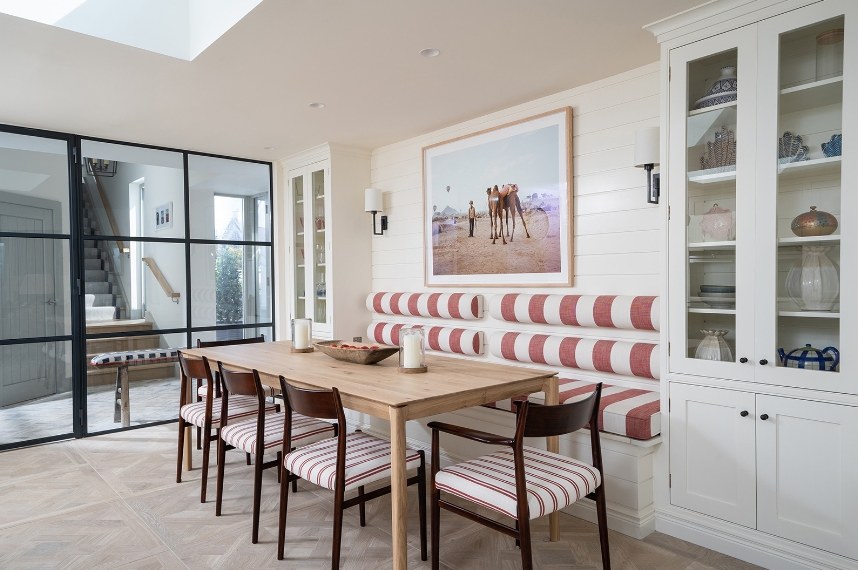 Dining area with striped banquette seating and oak table